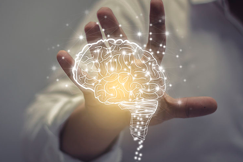 cerebro transparente y brillante frente a una mano